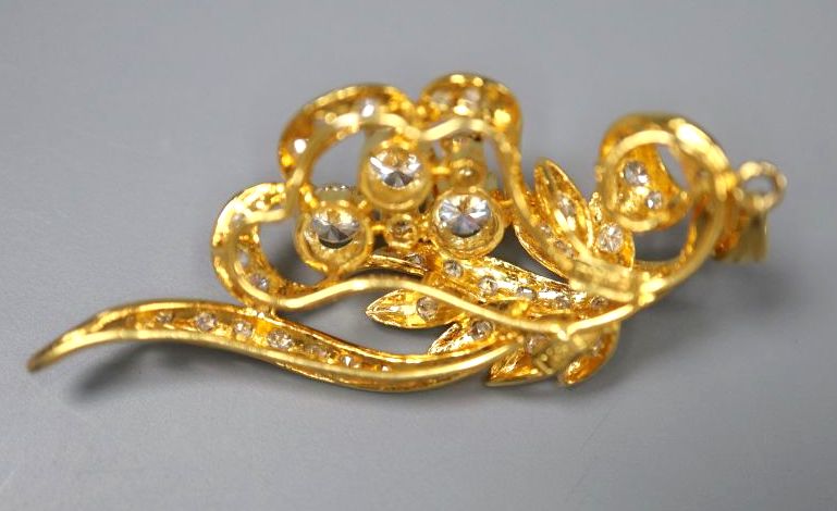 A modern yellow metal (stamped 8k) and diamond set foliate spray pendant, 40mm, gross 5.7grams.